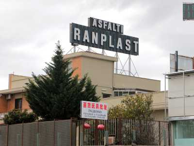 Pi� avanti un�enorme insegna con scritto �Asfalti Ranplast� sovrasta un altro ingrosso cinese di casalinghi e giocattoli. L�azienda di asfalto e bitumi � ormai chiusa da tempo e i cinesi hanno comprato questo edificio senza preoccuparsi di sostituire il vessillo. L�edificio rossiccio, circondato da tante tipiche lanterne rosse contiene ancora uffici in fittasi
